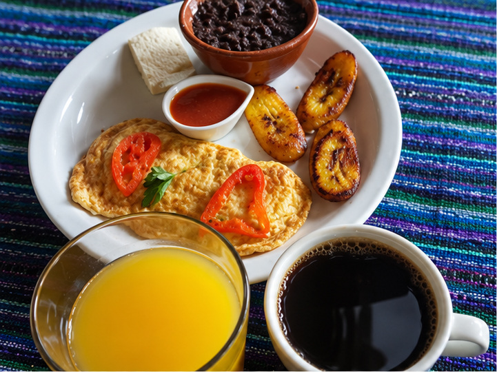 Desayuno con huevos, frijoles, plátanos y café